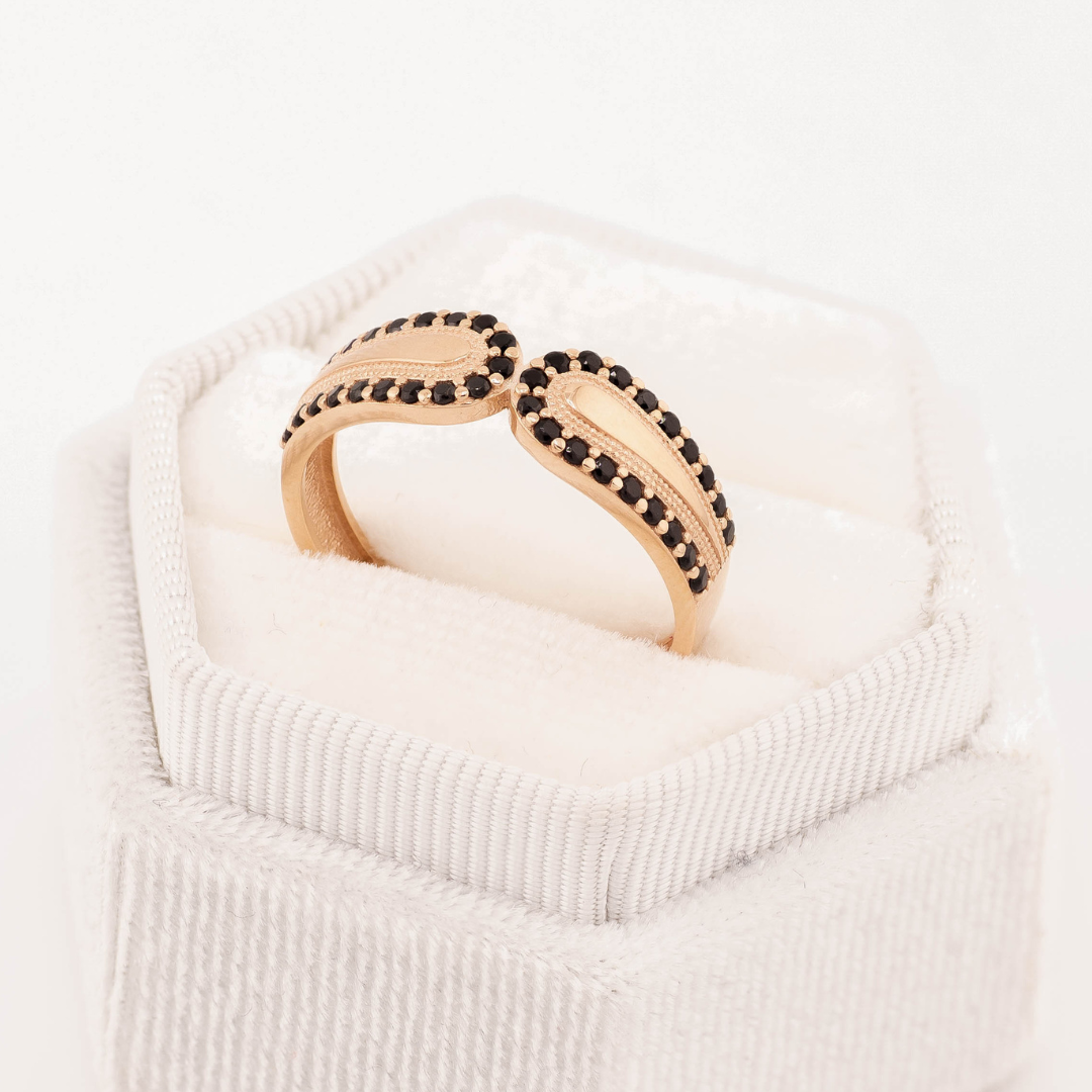 Rožinio aukso žiedas su tekstūrinėmis detalėmis ir aplink kraštą išdėstytais juodais cirkoniais