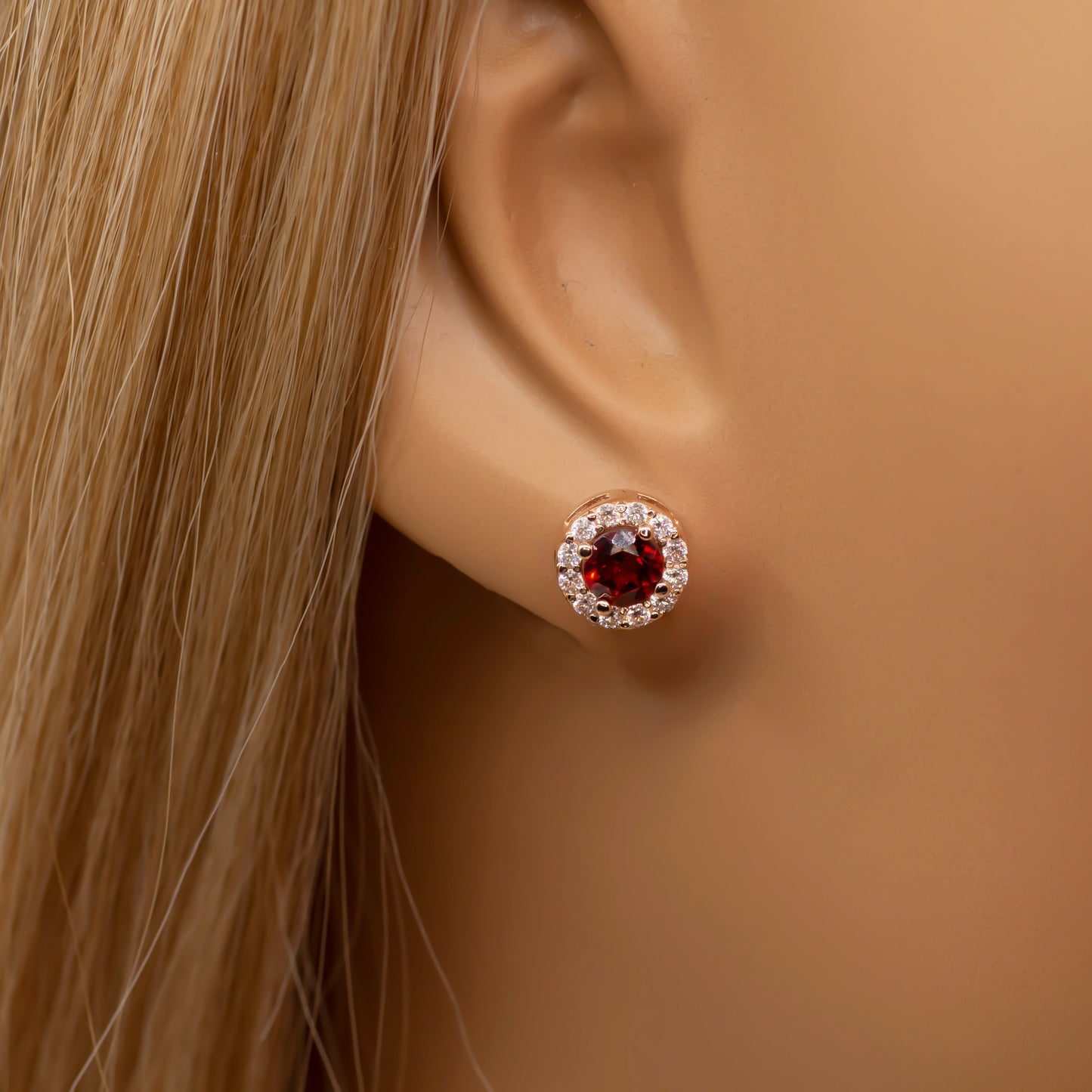 Šie apvalūs auskarai, pagaminti iš 585 aukso, yra papuošti natūraliais akmenimis, suteikiančiais ypatingo žavesio. Auskarus galite pasirinkti iš dviejų variantų – mėlynojo topazo arba raudonojo granato. Aplink akmenį išdėstyti smulkūs balti cirkoniai, kurie dar labiau paryškina akmens grožį. Auskarai sveria 2.50 g, tad yra lengvi ir patogūs kasdieniam dėvėjimui ar ypatingoms progoms.