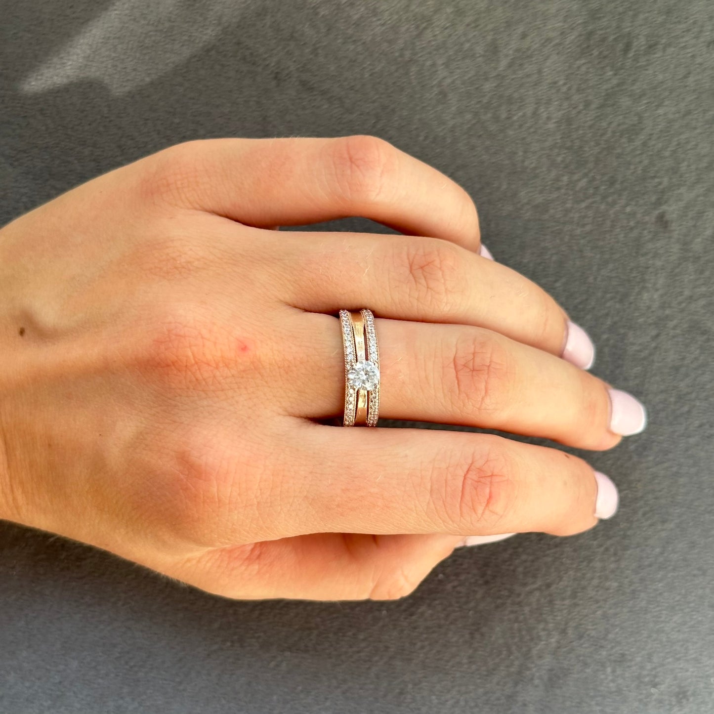 Modernus auksinis žiedas, pagamintas iš 585 raudonojo aukso, sveria apie 3.05 g ir pasižymi išskirtiniu dizainu. Dizaino akcentai suteikia žiedui unikalumo, todėl jis puikiai tinka tiems, kurie nori išsiskirti. Šis žiedas ne tik pabrėžia Jūsų asmeninį stilių, bet ir yra komfortiškas dėvėti, todėl jis idealiai tinka tiek kasdieniam naudojimui, tiek ypatingoms progoms, suteikiant Jums elegancijos ir spindesio.