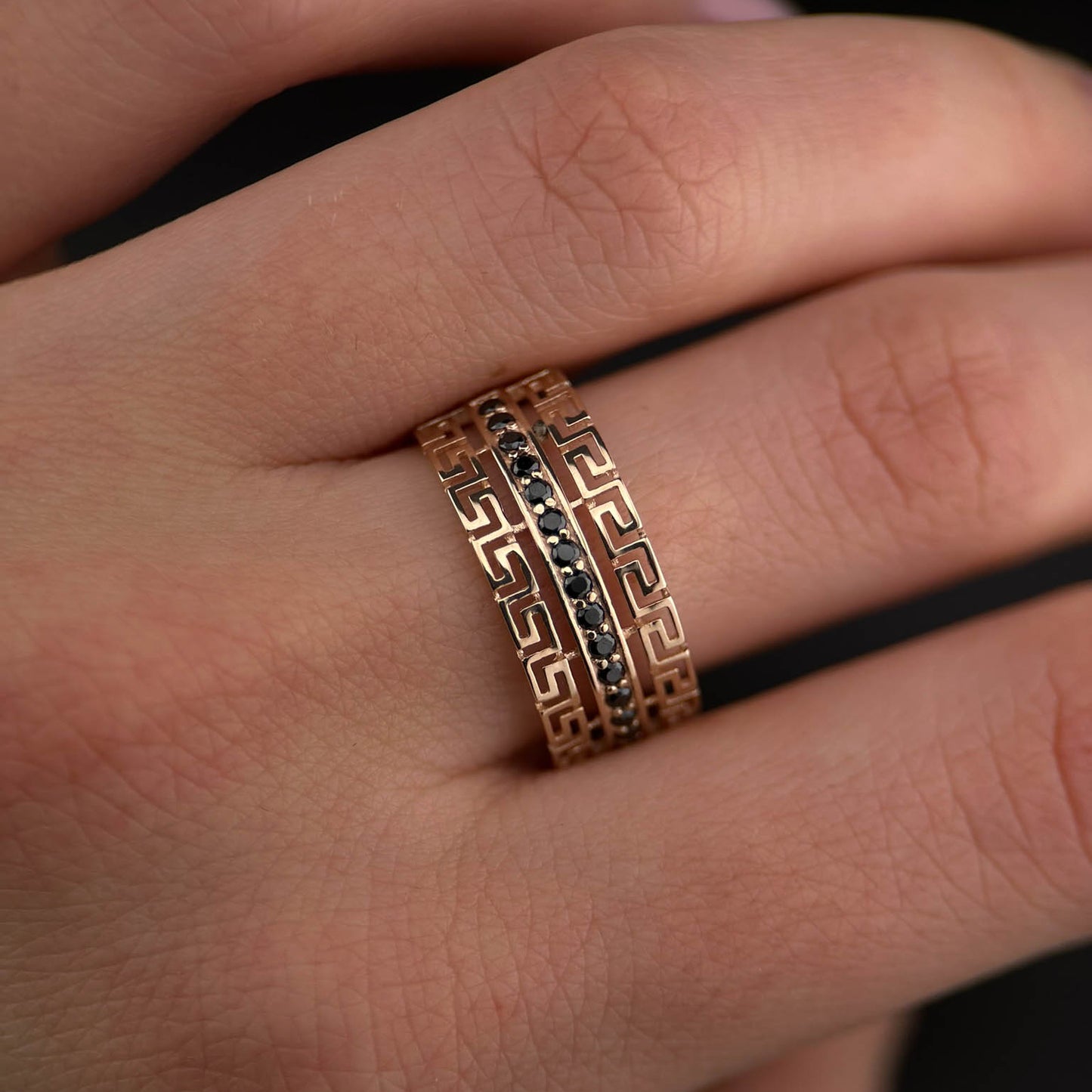 Raudono aukso žiedas su graikišku frezo raštu ir centrine juoda cirkonių linija