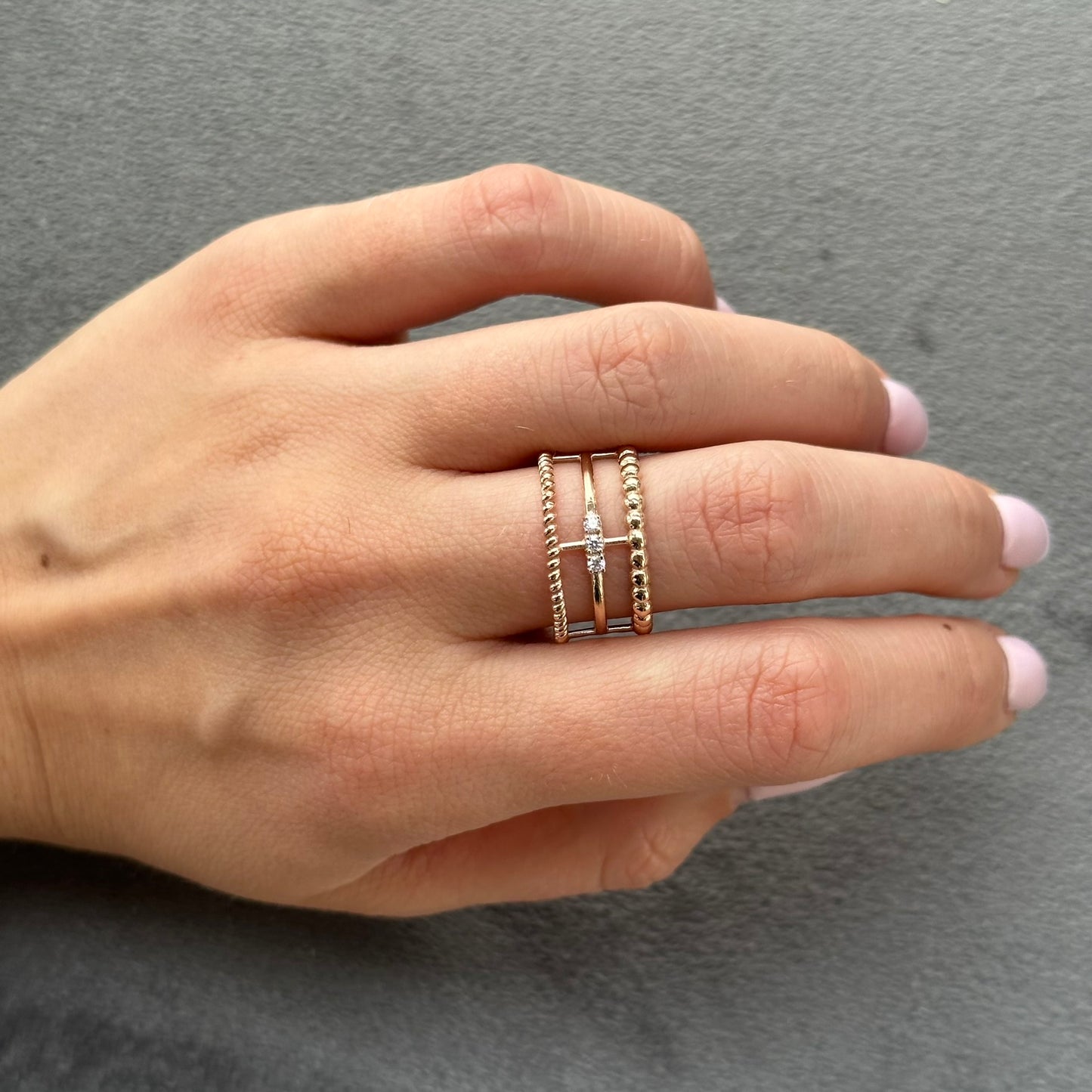 ožinio aukso žiedas su trijų tekstūrų juostomis – viršuje sraigtinė, apačioje burbuliuota, centre trys maži cirkoniai