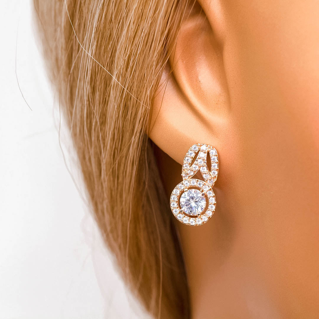 Auskarai pagaminti iš 585 prabos aukso, jų svoris yra apie 4,54 g. Jie inkrustuoti cirkoniais ir yra su anglišku užsegimu, kuris užtikrina saugų ir patogų dėvėjimą. Galima pasirinkti su baltais arba juodais cirkoniais.