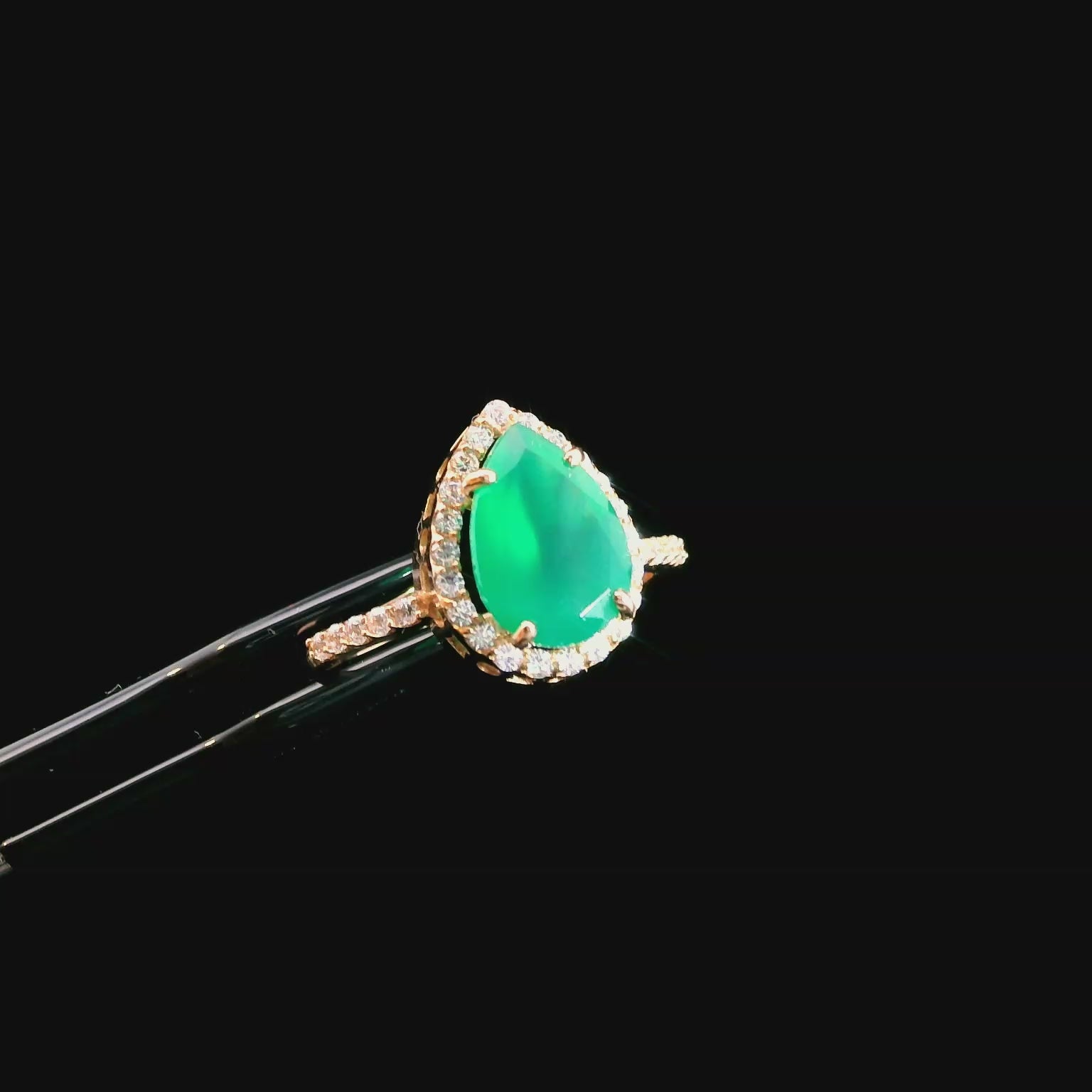 Šis auksinis lašo formos žiedas iš 585 raudono aukso yra tikras elegancijos simbolis. Žiedo centre esantis natūralus akmuo ne tik suteikia ypatingą grožį, bet ir pabrėžia kiekvieno akmens unikalumą. Aplink pagrindinį akmenį subtiliai įkomponuoti balti cirkoniai suteikia papildomo švytėjimo ir išryškina jo prabangų dizainą. Sveriantis apie 2.20g, šis žiedas ne tik traukia akį, bet ir yra maloniai lengvas bei patogus nešioti.